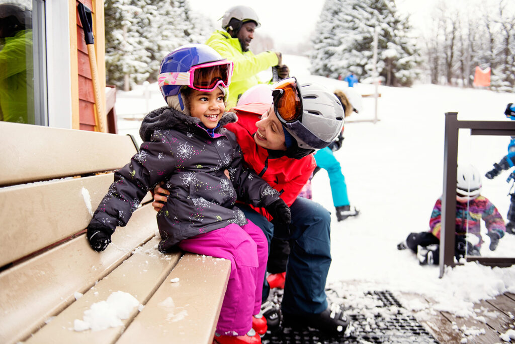 Black father with his multi daughter and son and his caucasian ethnicity wife skying during an afternoon day in a small town in Quebec Canada. It was their first time skying. They are with their caucasian friends. The color and horizontal photo was taken in Quebec Canada.